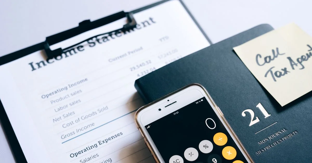 Gros plan sur un relevé de revenus, une calculatrice et un planner pour la planification financière.