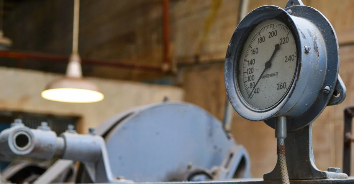 Vue détaillée d'un ancien manomètre industriel dans un atelier.