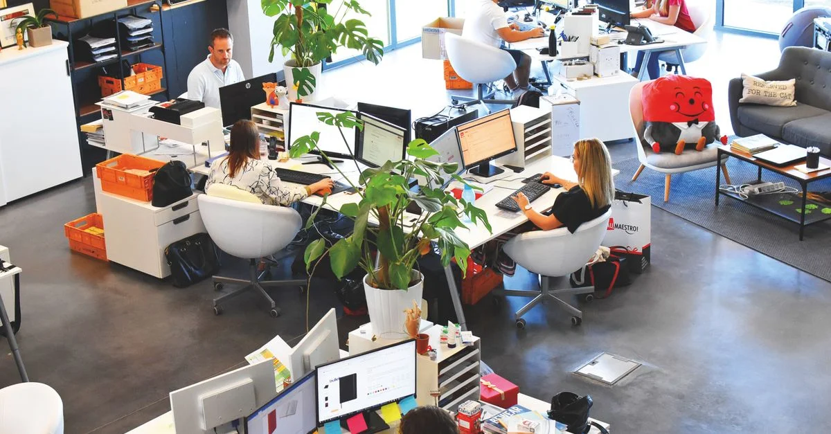 Un bureau moderne et dynamique avec des employés collaborant à leurs bureaux.