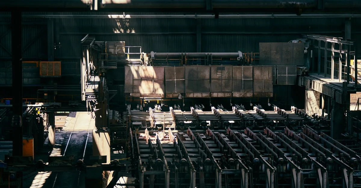 Vue intérieure d'une grande usine industrielle montrant des machines et des équipements.