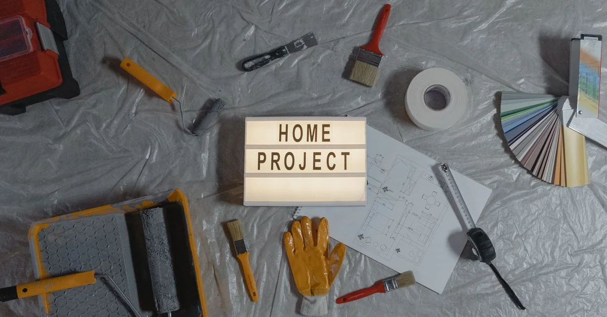 Vue de dessus des outils d'amélioration de l'habitat, échantillons de peinture et plans pour un projet DIY.
