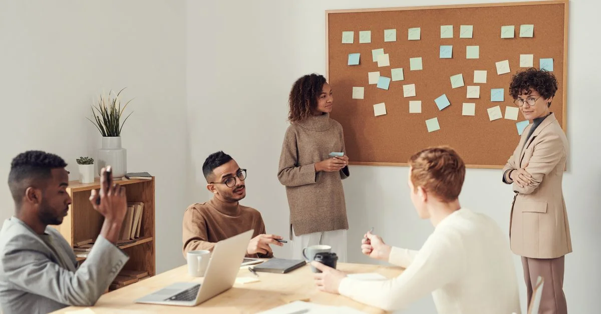 Un groupe diversifié de professionnels collaborant dans un environnement de bureau moderne lors d'une session de brainstorming.