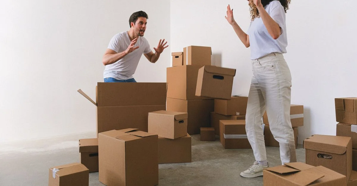 Un jeune couple s'amusant et déballant des cartons dans leur appartement moderne.