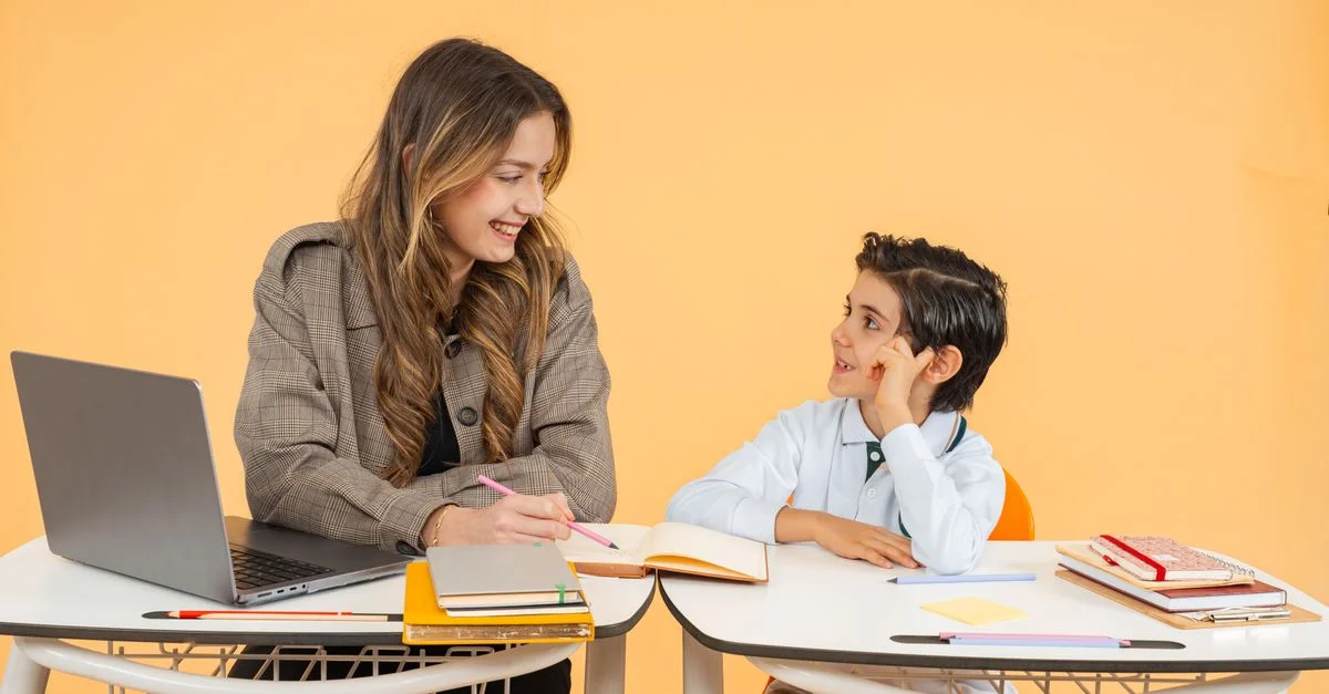 Un enseignant et un élève sourient en participant à une activité d'apprentissage dans une salle de classe.