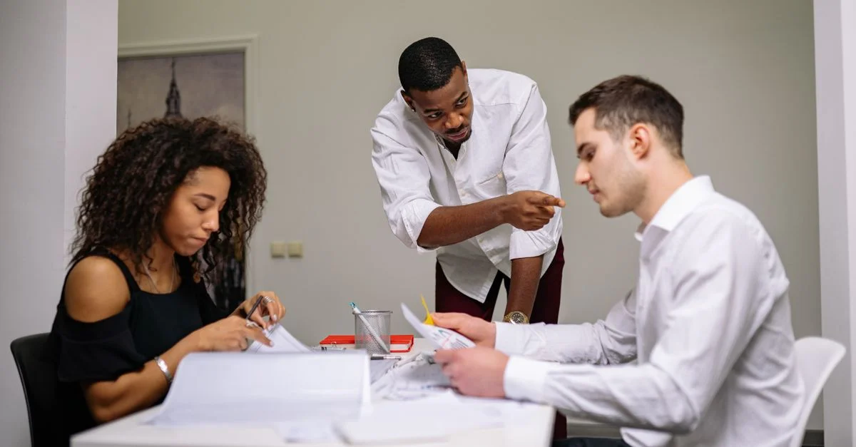 Gestionnaire instruisant des employés lors d'une réunion d'équipe concentrée dans un bureau moderne.