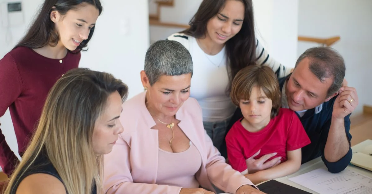 Une famille discute de documents immobiliers à la maison avec un agent, favorisant la communication et la planification.