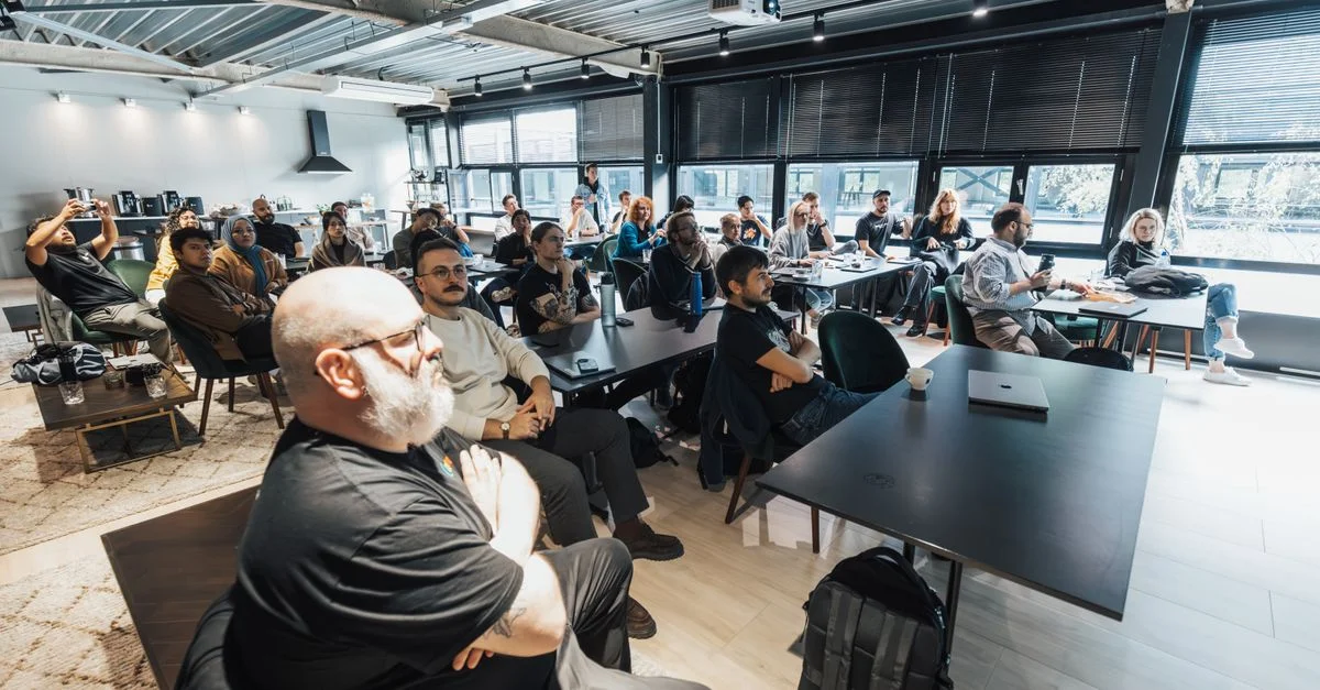 Un groupe diversifié de professionnels écoutant attentivement lors d'une réunion d'affaires en intérieur dans une salle de conférence moderne.