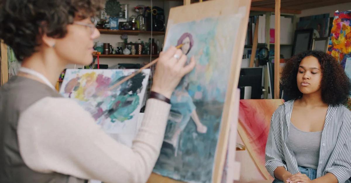 Un artiste peint le portrait d'une jeune femme dans un atelier d'artiste.