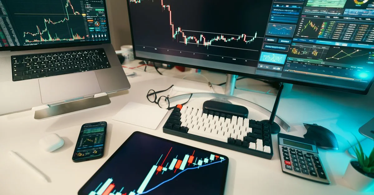 Un bureau de trading moderne avec des écrans affichant des tableaux et des graphiques financiers, présentant une configuration d'analyse numérique.